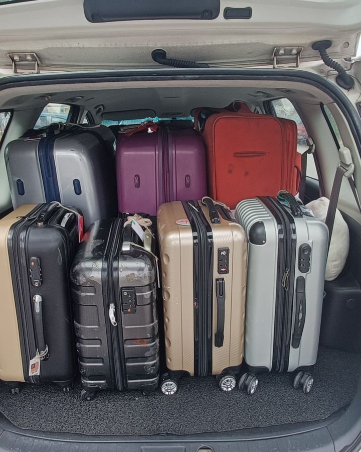 Suitcases packed into the boot of our white Proton Exora on a real trip