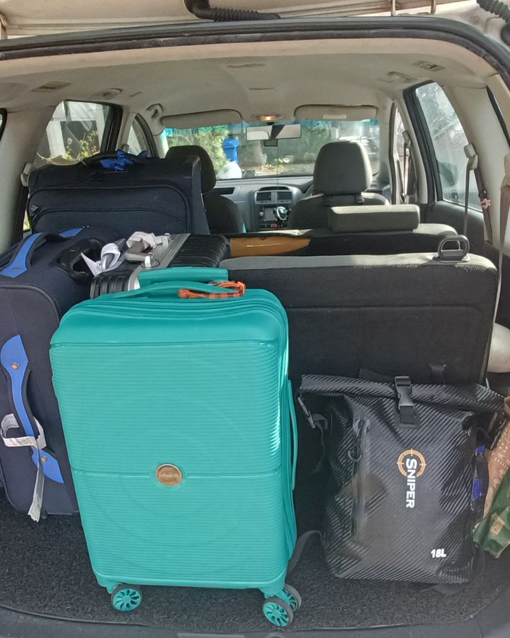 Suitcases packed into the boot of our white Proton Exora on a real trip