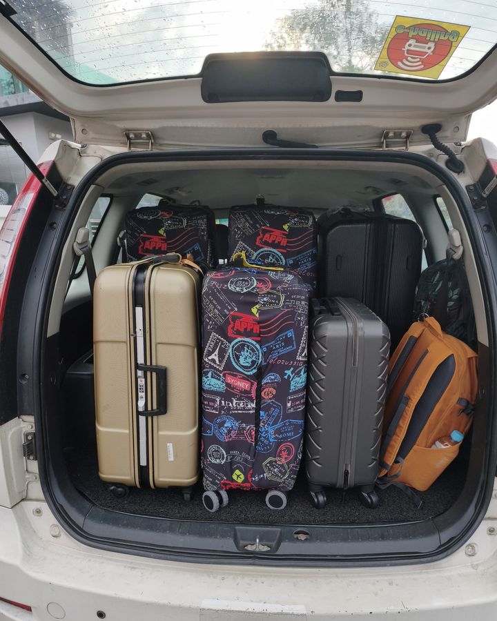 Suitcases packed into the boot of our white Proton Exora on a real trip