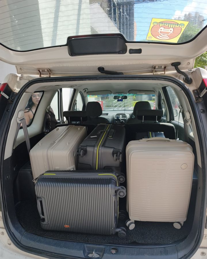 Suitcases packed into the boot of our white Proton Exora on a real trip